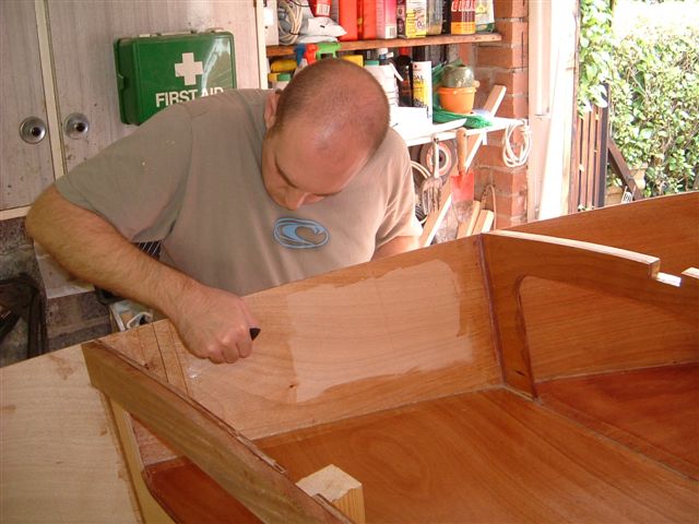 Coating the inside of he hull with epoxy. Tank top and king post glassed in position.